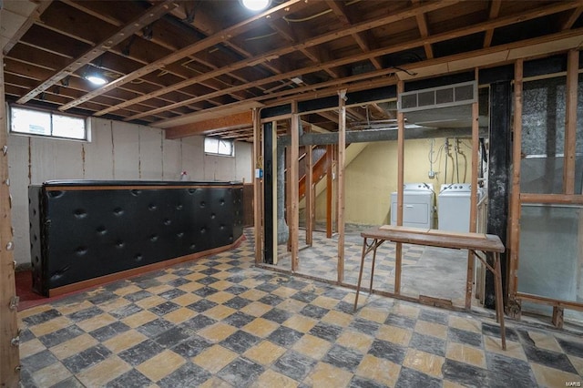 basement with tile patterned floors, visible vents, and washer and clothes dryer