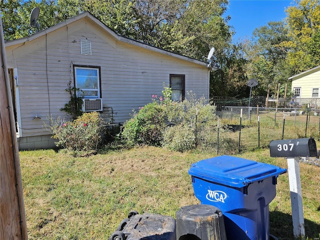 view of home's exterior featuring a lawn, fence, and cooling unit