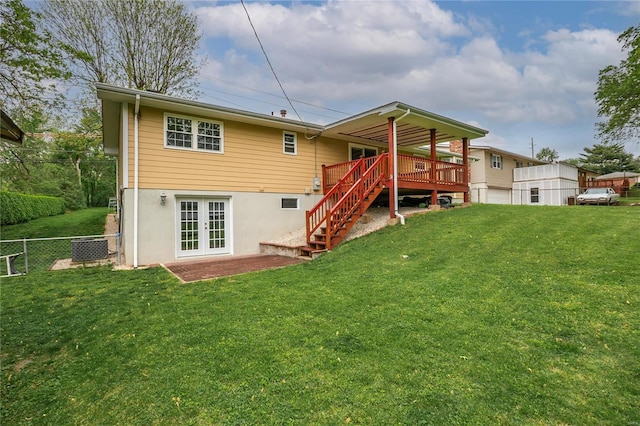 rear view of property with french doors, fence, a lawn, and stairway