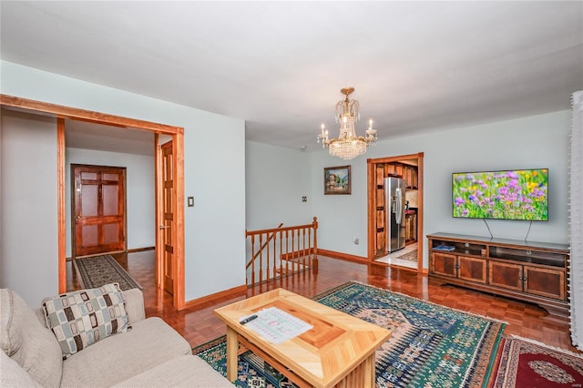 living area featuring baseboards and a notable chandelier
