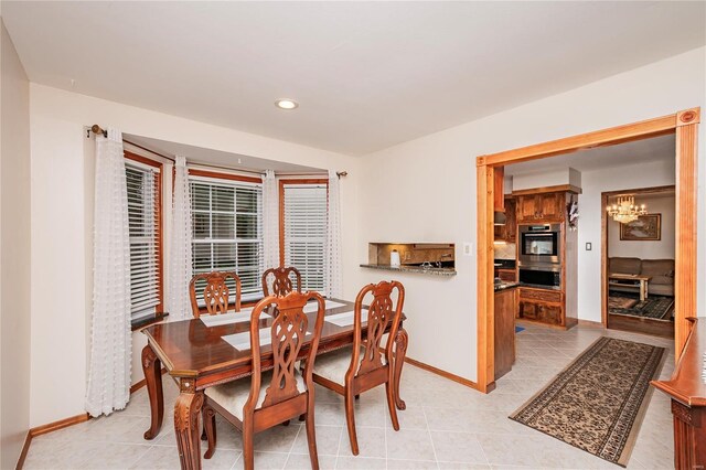 dining area featuring baseboards, recessed lighting, light tile patterned flooring, and a notable chandelier