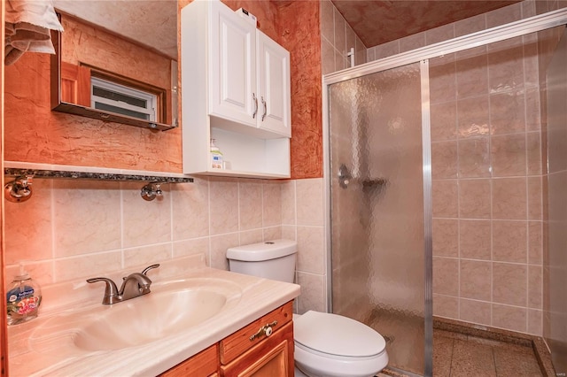 bathroom featuring vanity, toilet, tile walls, and a stall shower