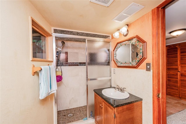full bath with visible vents, vanity, and a shower stall