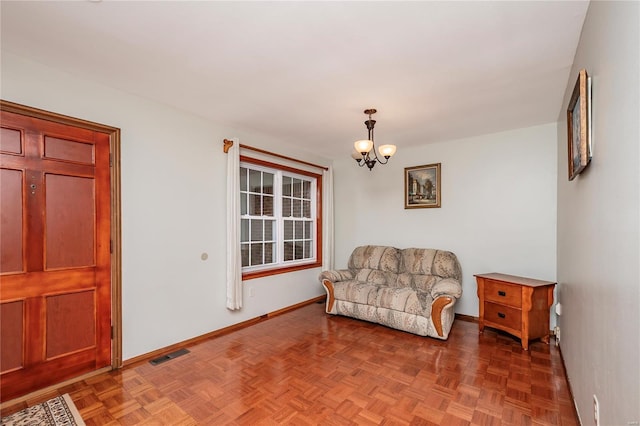 sitting room featuring baseboards, visible vents, and an inviting chandelier