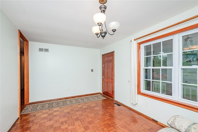 interior space featuring an inviting chandelier, baseboards, and visible vents