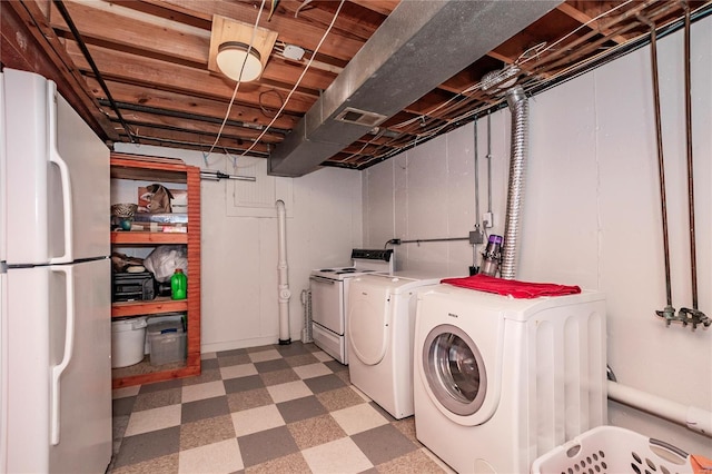 clothes washing area featuring tile patterned floors, laundry area, separate washer and dryer, and visible vents