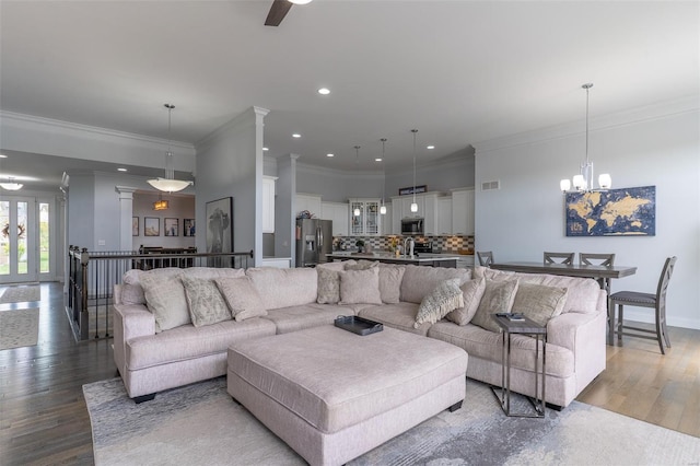 living room with recessed lighting, light wood-style flooring, ornamental molding, baseboards, and visible vents