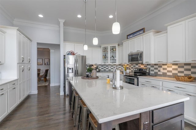 kitchen with decorative backsplash, a spacious island, decorative columns, stainless steel appliances, and a kitchen breakfast bar