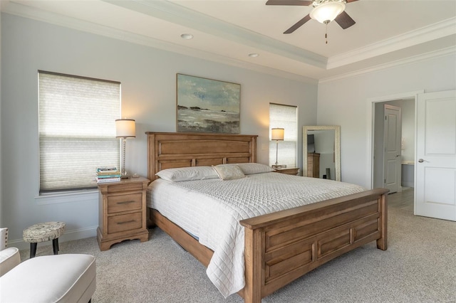 bedroom with ceiling fan, a raised ceiling, baseboards, ornamental molding, and light colored carpet