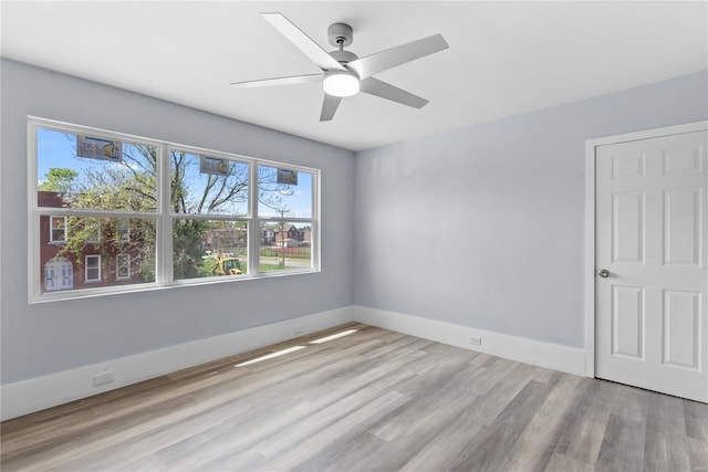 unfurnished room with ceiling fan, wood finished floors, and baseboards