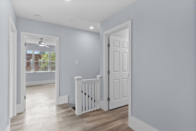 hallway featuring recessed lighting, an upstairs landing, wood finished floors, and baseboards