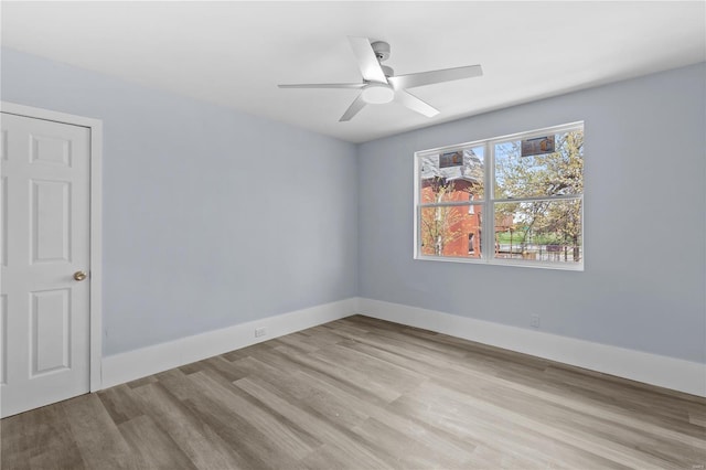 empty room featuring a ceiling fan, wood finished floors, and baseboards