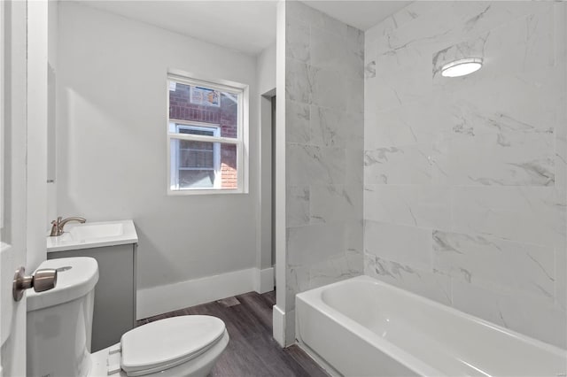 bathroom featuring wood finished floors, toilet, vanity, and baseboards