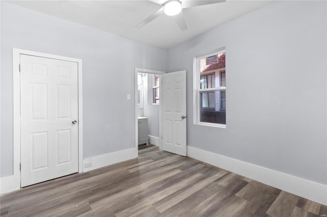 unfurnished bedroom with baseboards, wood finished floors, and ceiling fan