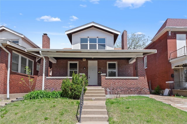 bungalow-style home featuring brick siding, a front yard, covered porch, and a chimney