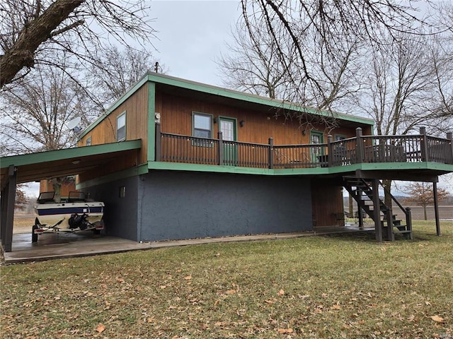 rear view of property with a deck, a yard, and stairway