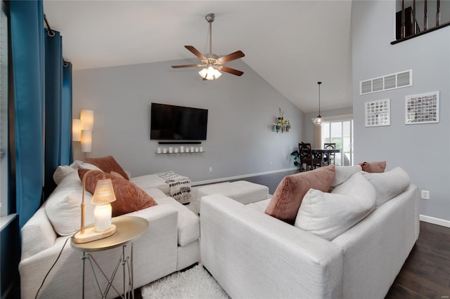 living area with ceiling fan, visible vents, wood finished floors, baseboards, and high vaulted ceiling