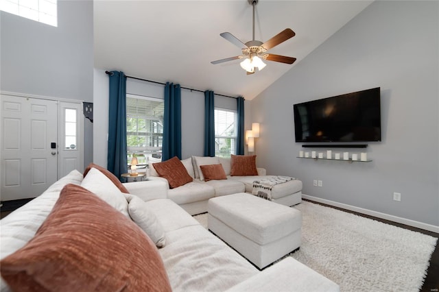 living area featuring baseboards, a ceiling fan, and high vaulted ceiling