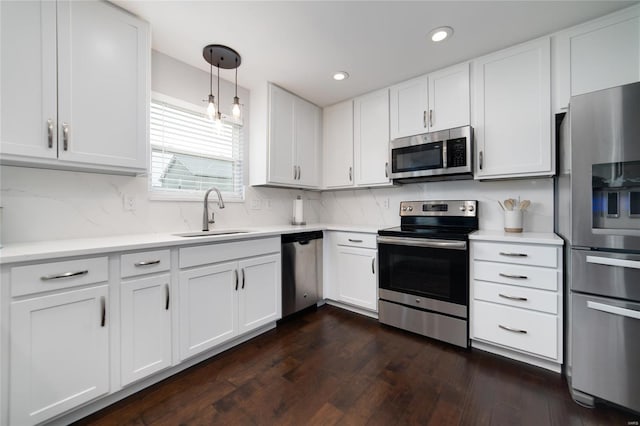 kitchen featuring dark wood-type flooring, light countertops, white cabinets, a sink, and stainless steel appliances
