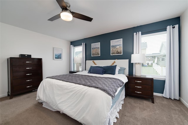bedroom featuring a ceiling fan, baseboards, and light carpet