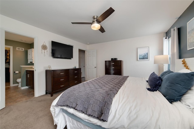 bedroom featuring visible vents, light carpet, baseboards, a ceiling fan, and ensuite bath
