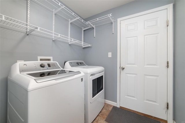 laundry room with laundry area, baseboards, and washing machine and dryer