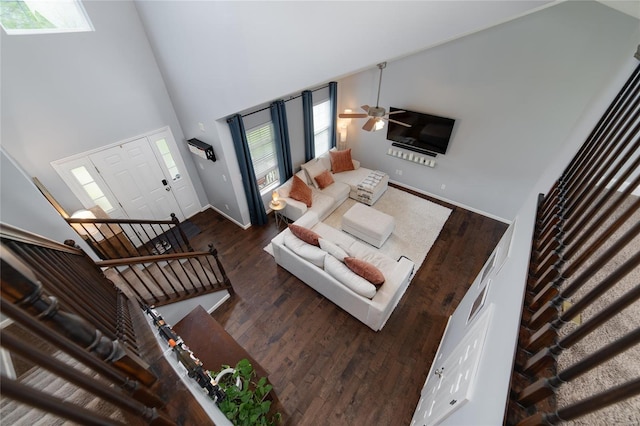 living room with baseboards, a high ceiling, ceiling fan, and wood finished floors