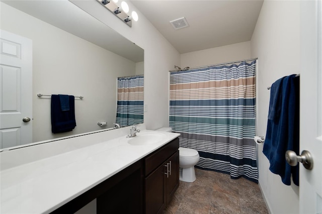 bathroom featuring stone finish flooring, toilet, visible vents, and vanity