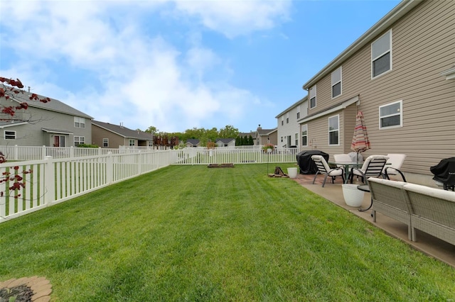 view of yard featuring a patio, a fenced backyard, and a residential view