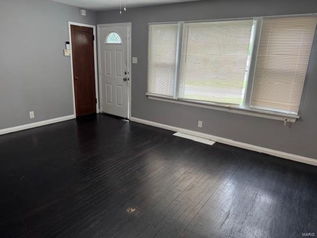 foyer featuring baseboards, ceiling fan, a wealth of natural light, and dark wood-style floors