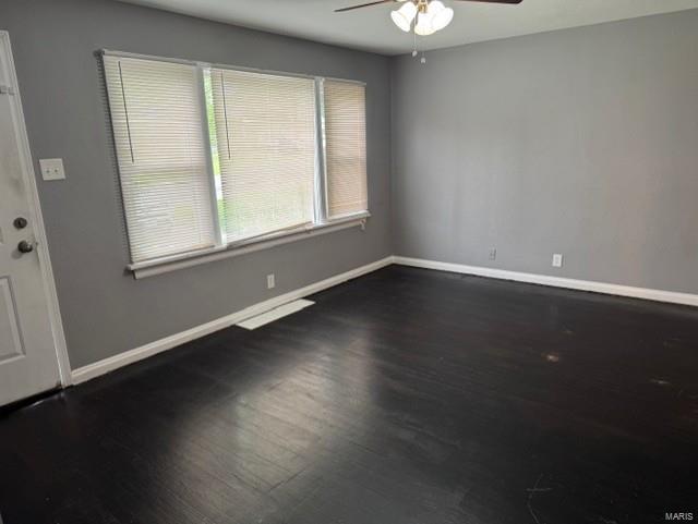 unfurnished room featuring baseboards, ceiling fan, and wood finished floors