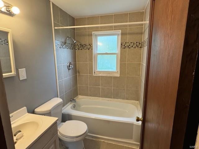 bathroom featuring toilet, washtub / shower combination, tile patterned flooring, and vanity