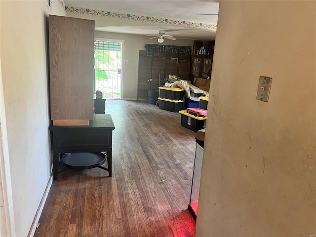 hallway featuring baseboards and wood finished floors