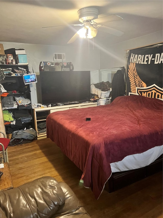 bedroom with a ceiling fan, wood finished floors, and visible vents