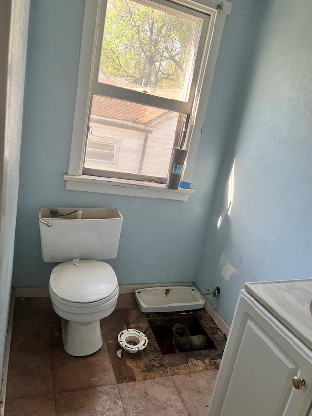 bathroom featuring baseboards, toilet, and vanity