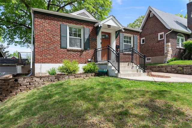 bungalow-style house featuring brick siding and a front yard
