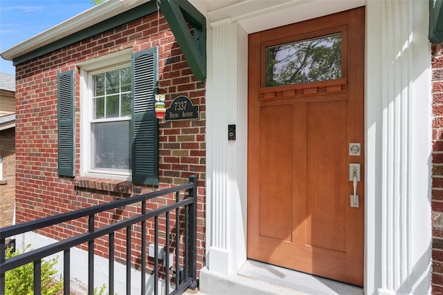 entrance to property featuring brick siding
