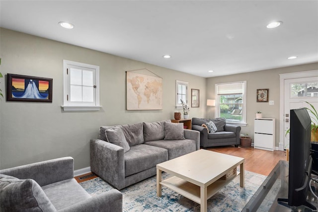 living room with baseboards, plenty of natural light, recessed lighting, and wood finished floors