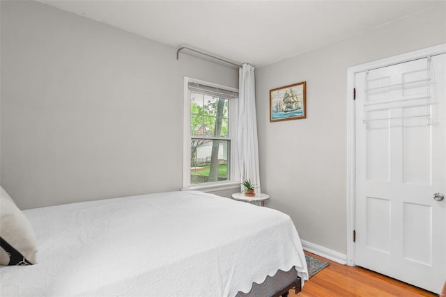bedroom featuring light wood-style floors and baseboards