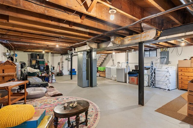 unfinished basement with heating unit, stairs, and independent washer and dryer