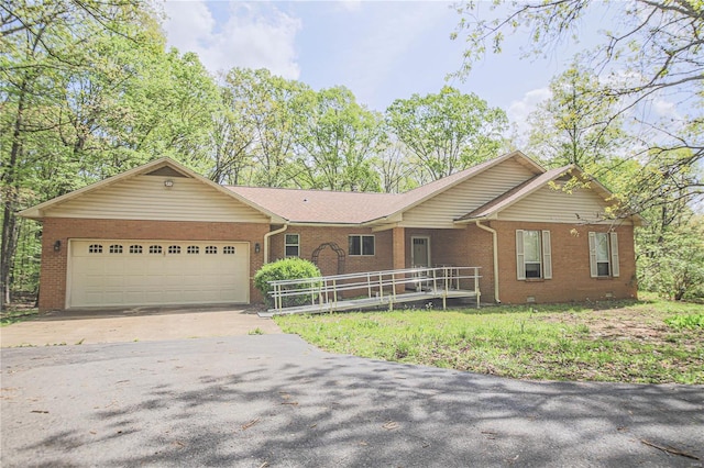 ranch-style home with driveway, an attached garage, and brick siding