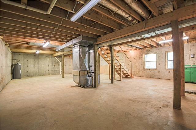 below grade area featuring heating unit, stairs, and electric water heater