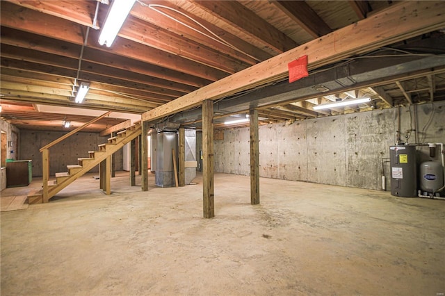 unfinished below grade area featuring water heater and stairs
