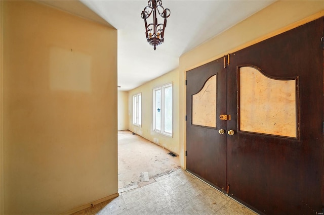 foyer entrance with visible vents, baseboards, light floors, and french doors