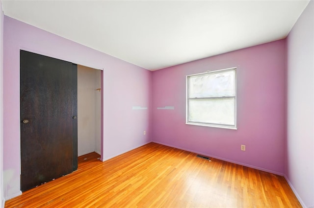 unfurnished bedroom featuring a closet, visible vents, and light wood-type flooring