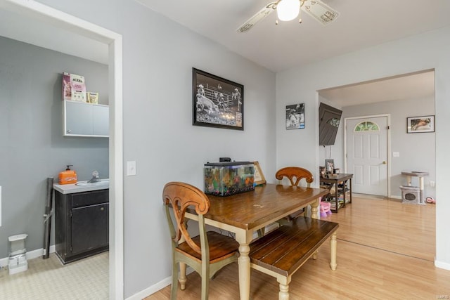 dining area featuring baseboards, ceiling fan, and light wood-style flooring