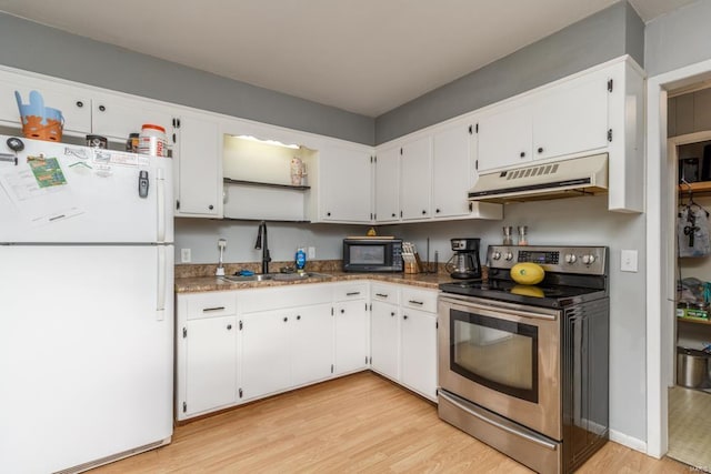 kitchen featuring a sink, freestanding refrigerator, under cabinet range hood, light wood finished floors, and stainless steel electric range