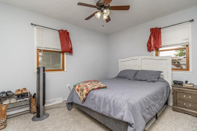 carpeted bedroom featuring ceiling fan and baseboards