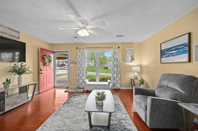 living area with visible vents, wood finished floors, and ceiling fan