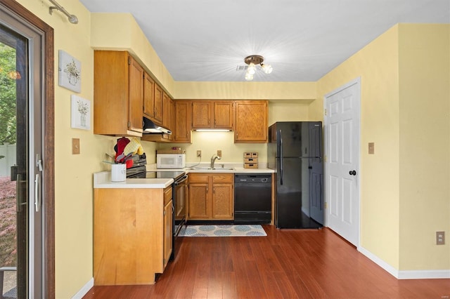 kitchen with dark wood-style floors, black appliances, and under cabinet range hood